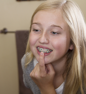 Teen pointing to her braces
